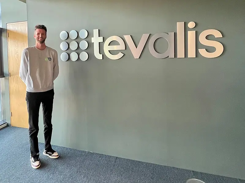 Photo of Will next to signage for Tevalis where he started his long-term career as an apprentice