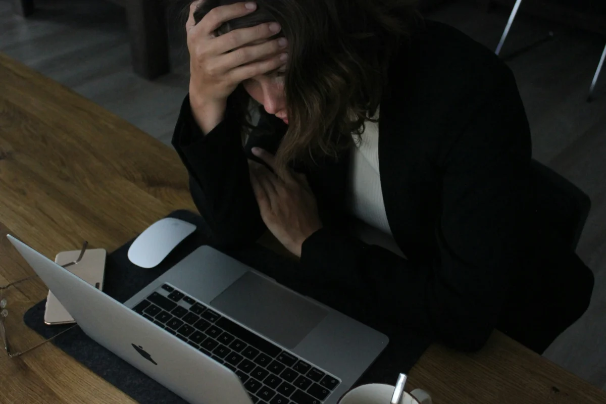Photo of someone who may be struggling at work. Supporting wellbeing at work is part of safeguarding.